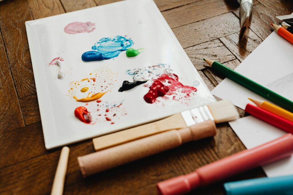A palette with vibrant paints surrounded by art tools, ready for creativity.